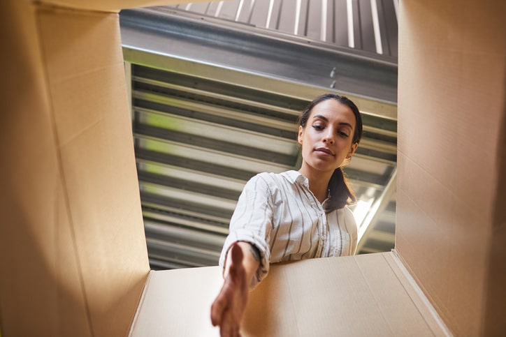 A woman reaching inside of a box at a storage facility